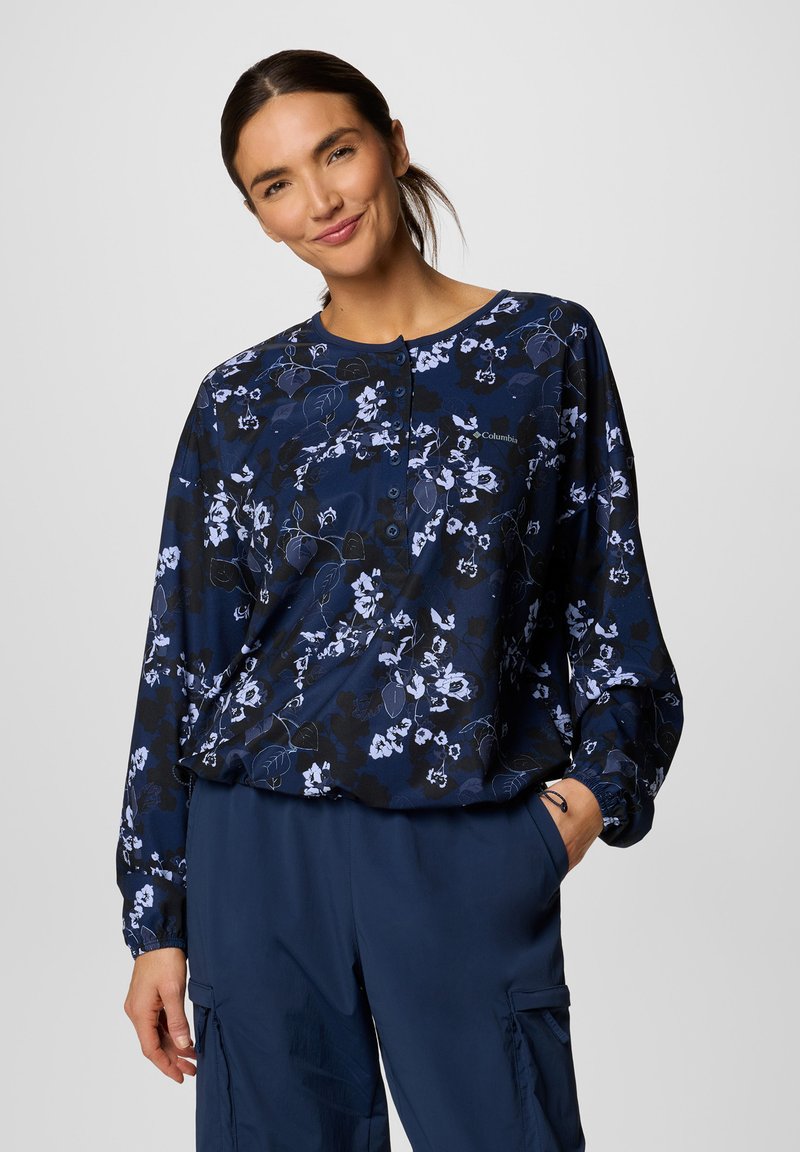 Bluse mit langen Ärmeln in Navy mit weißen und hellblauen Floral-Mustern, mit Rundhalsausschnitt und Knopfverschluss, aus einem weichen Stoff gefertigt.
