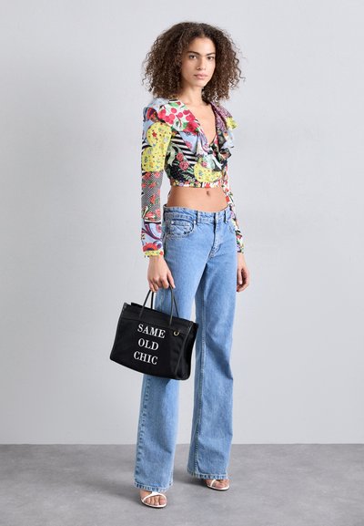 Mitmevärviline lühike pluus rüüsidega, kombineeritud helesiniste laiemate pükste ja musta käekotiga, millel on valgetes tähtedes kiri "SAME OLD CHIC".