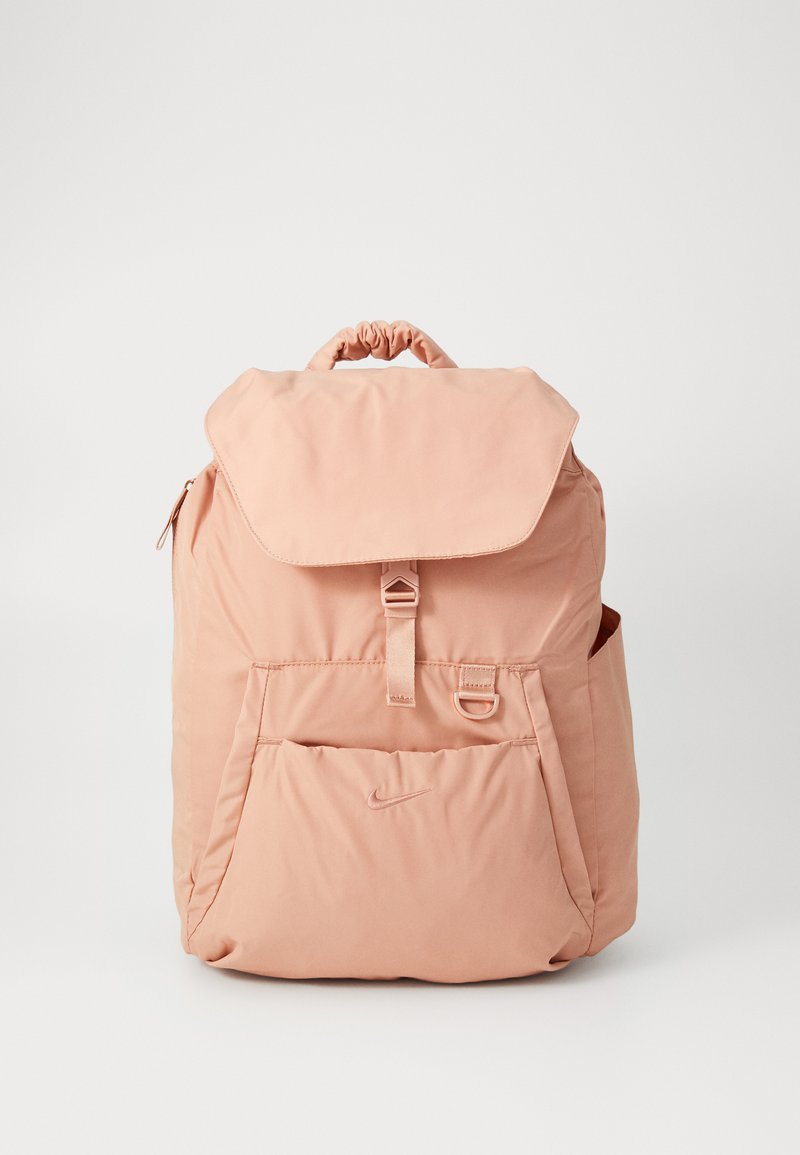 Rózsaszín nylon hátizsák összefogott tetejű, lapos fedéllel, elülső zsebbel és oldalsó hálós zsebbel. Elöl egy kis logó található. Simaság jellemzi.