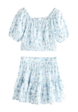 Jasnoniebieski kwiatowy krótki top z bufkami i dopasowaną marszczoną mini spódnicą, z małymi żółtymi i niebieskimi wzorami kwiatowymi.