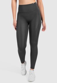 Leggings neri a vita alta realizzati in tessuto elastico, con una tasca laterale, superficie liscia e design aderente per un utilizzo attivo.