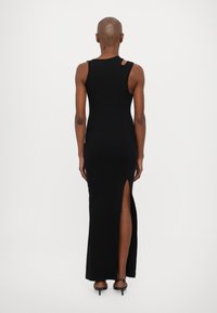 Black sleeveless maxi dress with a side slit, featuring a fitted design made of stretchy fabric and a distinctive shoulder cutout detail.
