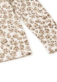 Halenka s leopardím vzorem z texturované látky, v neutrálních krémových a hnědých tónech. Mezi detaily najdeme žebrovaný design a prošívané lemy.