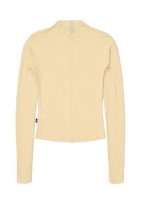 Pitkähihaisen puseron vaalea keltainen kangas, muotoon ommeltu malli, pyöreä kaula-aukko ja suora helma. Sivulla pieni brändilogo.