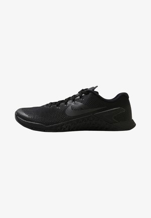 Chaussure de sport noire à profil bas avec semelle texturée, tige en mesh, lacets et logo Nike sur le côté, vue de l'extérieur.