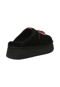 Black suede slip-on shoe with a thick black platform sole. Features colorful tassels and intricate embroidery on the upper.