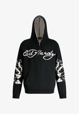 Black zip-up hoodie featuring a white logo "Ed Hardy" and intricate white designs on sleeves. Soft textured fabric with a hood.