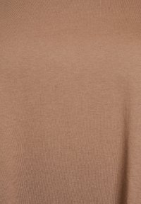 Braun gestrickter Stoff mit einer glatten Textur, der ein schlichtes Design und eine gleichmäßige Farbe über die gesamte Oberfläche aufweist.