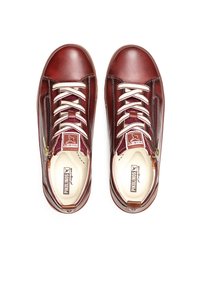Sneakers in pelle marrone con lacci bianchi, superficie testurizzata, dettaglio con zip sul lato e logo sulla linguetta. Design con punta arrotondata.