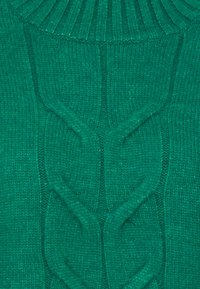 Zelený pletený svetr s žebrovaným límcem a texturovanými copánkovými vzory. Měkká příze s hladkým povrchem a jednotnou barvou po celém svetru.