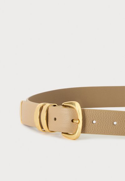 Ceinture en cuir beige avec boucle en métal doré et deux boucles dorées sur un fond uni clair.