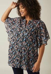 Blumenbluse mit navy Hintergrund, präsentiert mit einem geplizten Design, kurzen schwingenden Ärmeln und Knöpfen. Der Stoff ist leicht und durchsichtig.