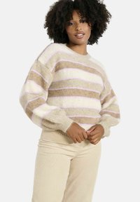 Adīta džemperis ar pelēkām, krēmīgām un gaiši rozā svītrām. Apaļa kakla izgriezums, garas pūka piedurknes un mīksta tekstūra. Kombinēts ar pelēkām akmens auduma biksēm.