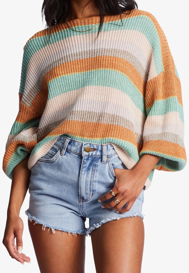 Strickpullover mit horizontalen Streifen in Blaugrün, Orange und Creme, kombiniert mit ausgefransten Jeansshorts. Lässige Passform, weite Ärmel, strukturierter Stoff.