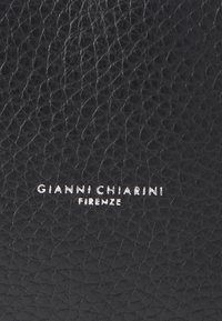 Fekete, szemcsés bőr texturált felülettel. Az alján ezüstösen dombornyomott "GIANNI CHIARINI FIRENZE" logós felirat található.