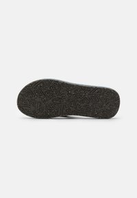Sole della scarpa caratterizzata da un design in gomma nera testurizzata e decorata con leggeri spruzzi. Forma arrotondata con un profilo piatto per una migliore aderenza.