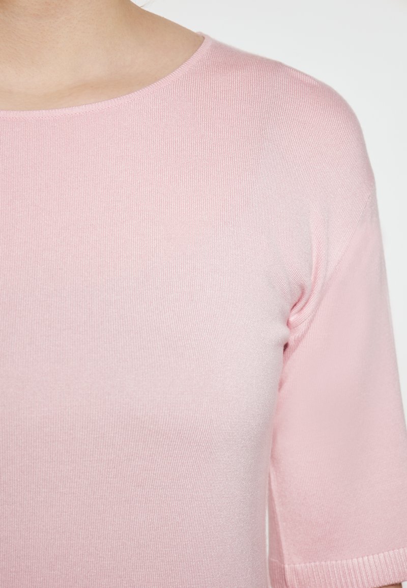 Roze top met korte mouwen van ribstof. Heeft een ronde halslijn en een gladde textuur, geschikt voor casual draagstijl.