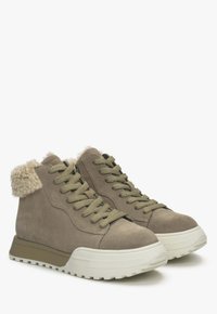 Słomkowe, zamszowe, wysokie sneakersy z teksturowanym kremowym futrem na kołnierzu, grubą białą gumową podeszwą i oliwkowymi sznurówkami.
