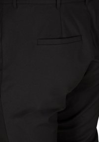 Svarta skräddarsydda byxor med en mjuk textur, slim fit och en bakficka med welt-design. Byxorna har bälteshällor och är utan dekorationer.