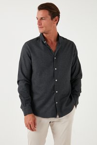 Camisa abotonada gris oscuro hecha de una tela texturizada, con cuello puntiagudo y botones blancos; mangas largas con puños.