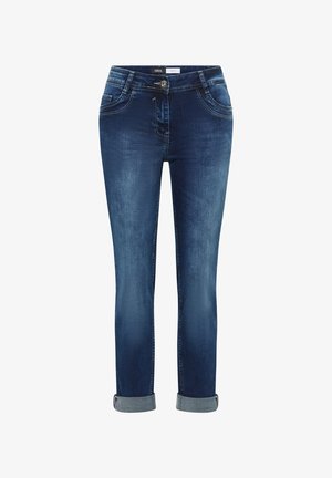 Tummansiniset farkut, joiden lahkeet ovat kääritty, edessä nappi ja vetoketju, kaksi etutaskua sekä vyötäröllä "Cecil"-merkki.