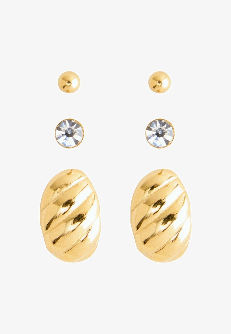 Quatre paires de boucles d'oreilles en or et en pierres précieuses disposées en rangées verticales sur un fond blanc.
