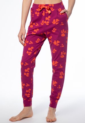 Fleece-Jogginghose in einem lebhaften Lila mit einem orangefarbenen abstrakten Muster. Verfügt über elastische Bündchen, einen Kordelzugbund und seitliche Taschen.