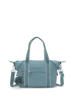 Teal fabric handbag with white stripes, dual handles, detachable shoulder strap, and a zippered front pocket. Features a pom-pom accessory.