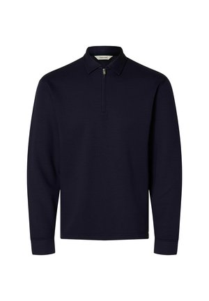 Tumši zils garroku tops ar īsu rāvējslēdzēju priekšpusē un smailu apkakli, izgatavots no gluda, viendabīga auduma.