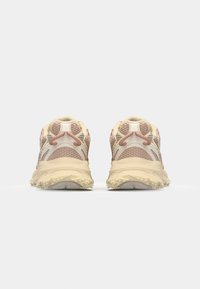 Běžecké boty v béžové a růžové barvě, s prodyšným síťovaným svrškem, texturovanými detaily a robustní podrážkou s hroty pro lepší trakci.