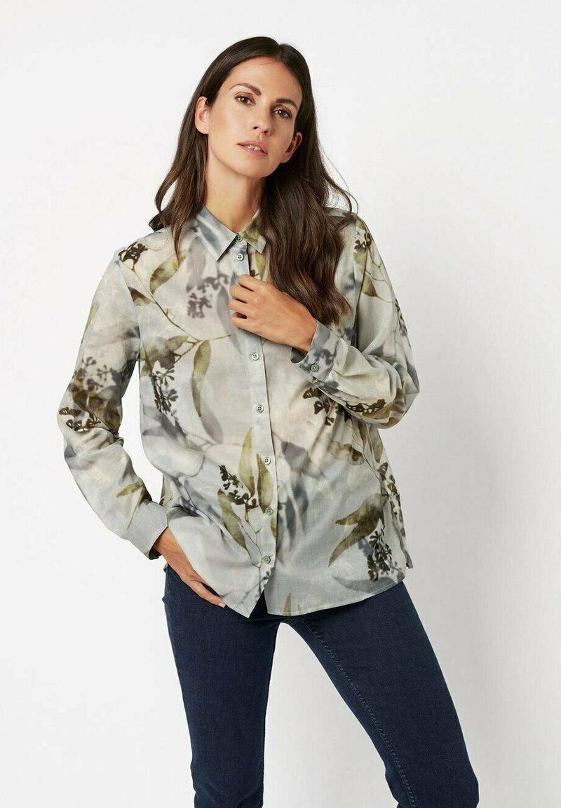 Floral button-up shirt in lightweight, textured fabric. Features gray tones with green and brown leaf patterns. Long sleeves with button cuffs.