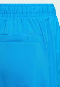 Modré šortky vyrobené z lehké tkaniny, s elastickým pasem, hladkým povrchem a jednou zadní kapsou.