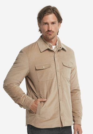 Beige kordfløjljakke med krave, frontknaplukning, to brystlommer og sidelommer til hænderne. Tekstureret stof. Casual fit.