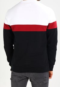 Sudadera para hombre en azul marino, blanco y rojo. Cuenta con un cuello redondo, mangas largas y diseño de bloques de color con puños y dobladillo acanalados.