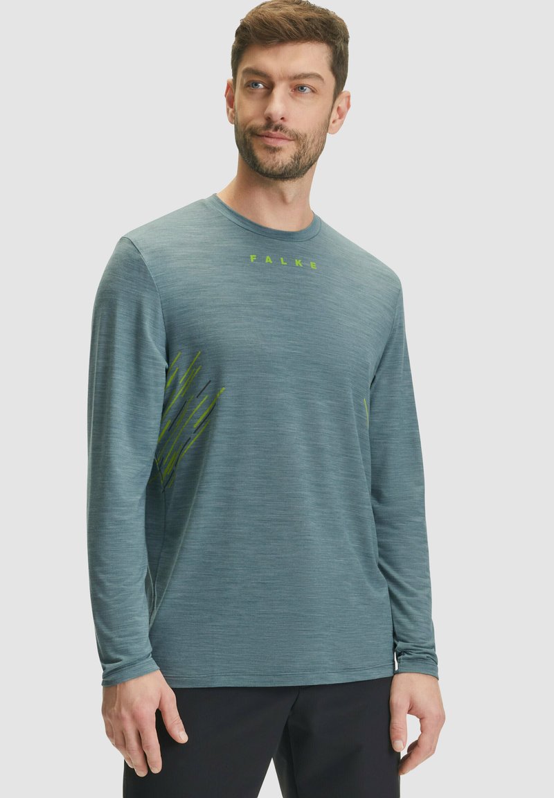 Maglietta atletica a maniche lunghe, di colore azzurro chiaro con una texture melangiata, caratterizzata da un logo verde e dettagli grafici sui lati. Vestibilità casual.