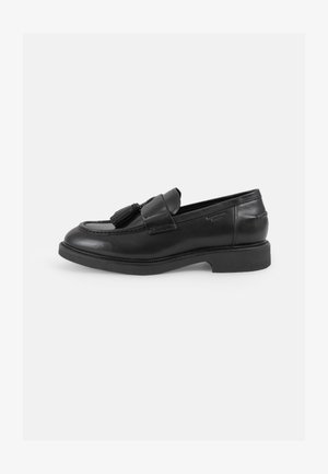 Zwarte leren instappers met een ronde neus, decoratieve franjes, gestikte details en een lage rubberen zool. Klassiek slip-on ontwerp.