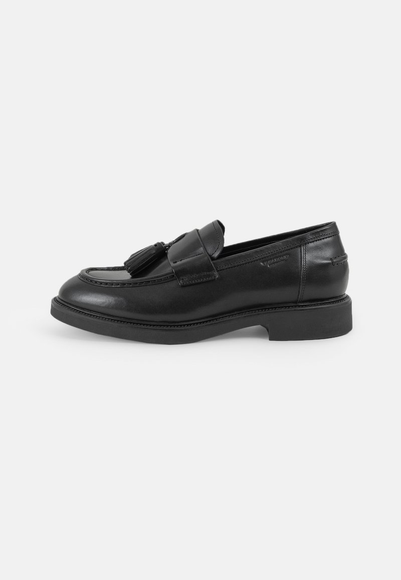 Mocasini din piele neagră cu vârful rotund, ciucuri decorativi, detalii cusute și o talpă joasă din cauciuc. Design clasic, ușor de încălțat.