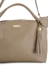 Beige leren handtas met een gestructureerd oppervlak, voorzien van een gouden logo plaat en een decoratieve kwast. Inclusief een schouderband.