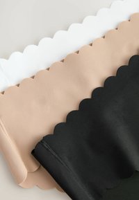 Drie stukjes stof in wit, nude en zwart, met gegolfde randen en een gladde textuur, horizontaal gerangschikt op een lichte achtergrond.
