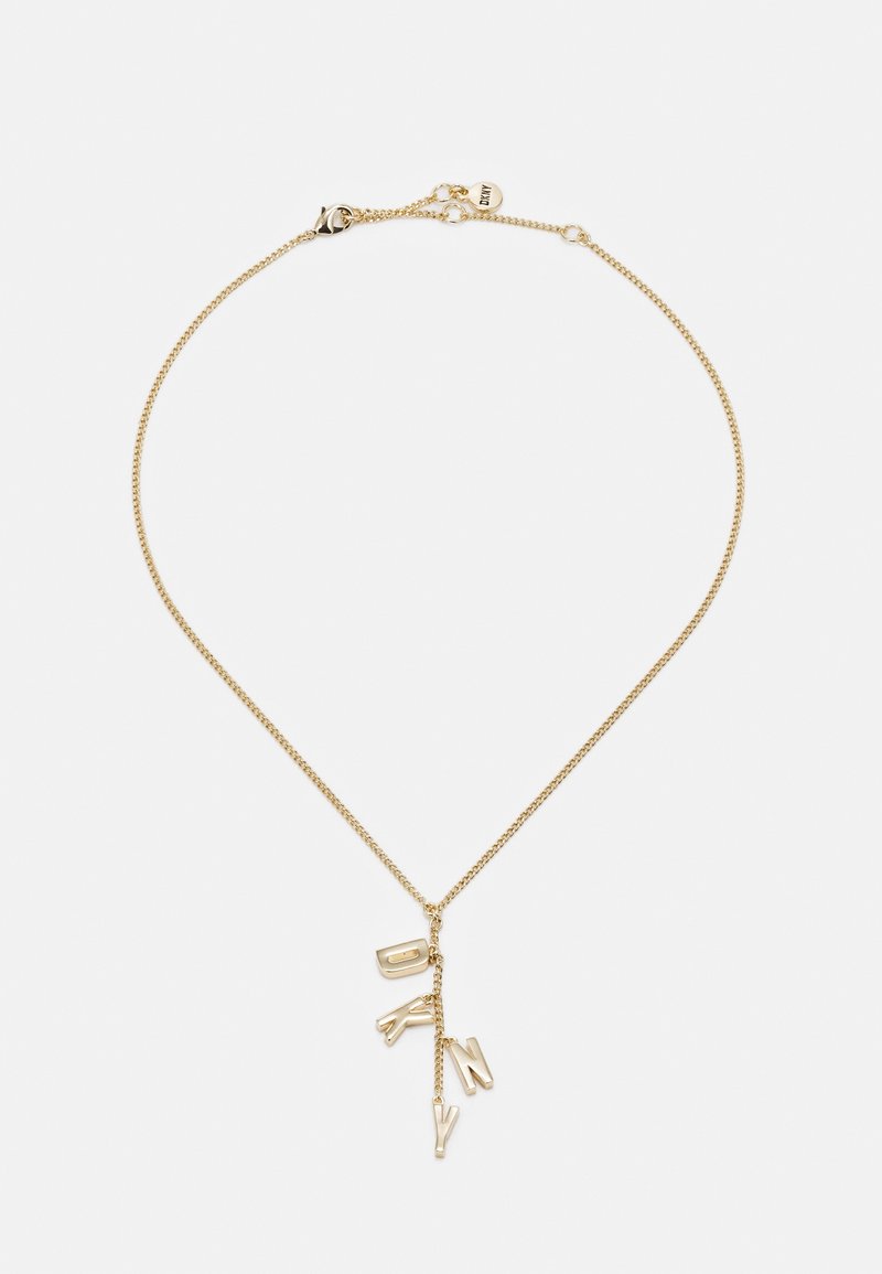 Collier délicat en chaîne d'or avec quatre breloques pendantes épelant "DKNY" sur fond blanc.