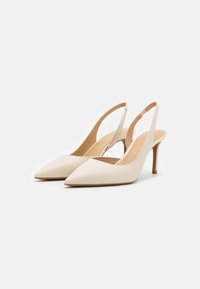 Beiga slingbackklackar med spetsiga tår, läderfinish, tunna stiletthälar och en V-formad utskärning framtill för extra detalj.