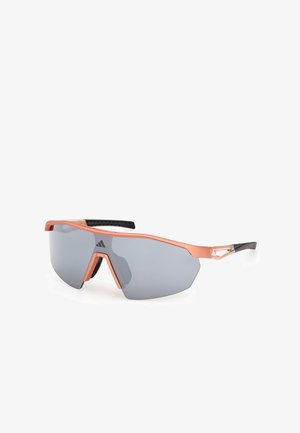 Sportovní sluneční brýle s černo-oranžovým rámečkem, šestihrannými šedými čočkami a strukturovanými stranicemi pro lepší úchop. Mají minimalistický design s kovovými akcenty.