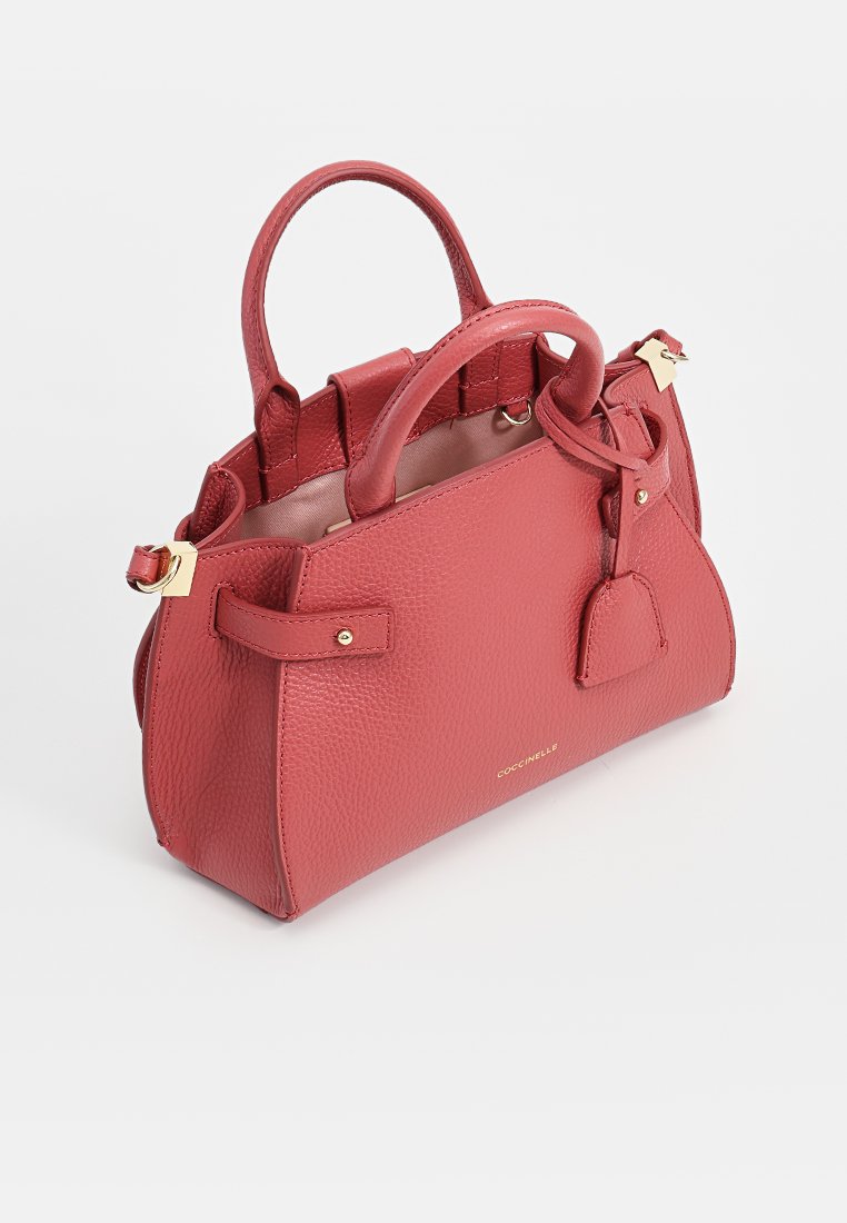 Borsa a mano in pelle rossa a ciottoli con doppi manici, accessori in metallo dorato e una targhetta rimovibile. Forma arrotondata con dettagli cuciti.