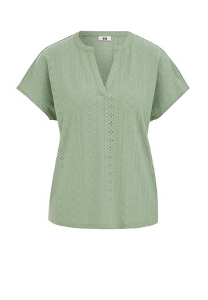 Šviesiai žalia trumpomis rankovėmis palaidinė su V formos iškirpte ir akių nėrinių raštu, kuriame yra geometrinių ir gėlių iškirpimų dizainai.