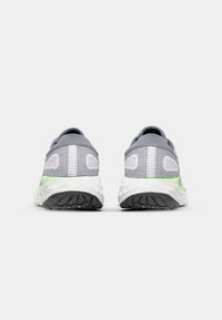 Chaussures de sport grises avec une tige en mesh, accents blancs et un détail vert vif sur la semelle intermédiaire. Présente une semelle extérieure à motif texturé.