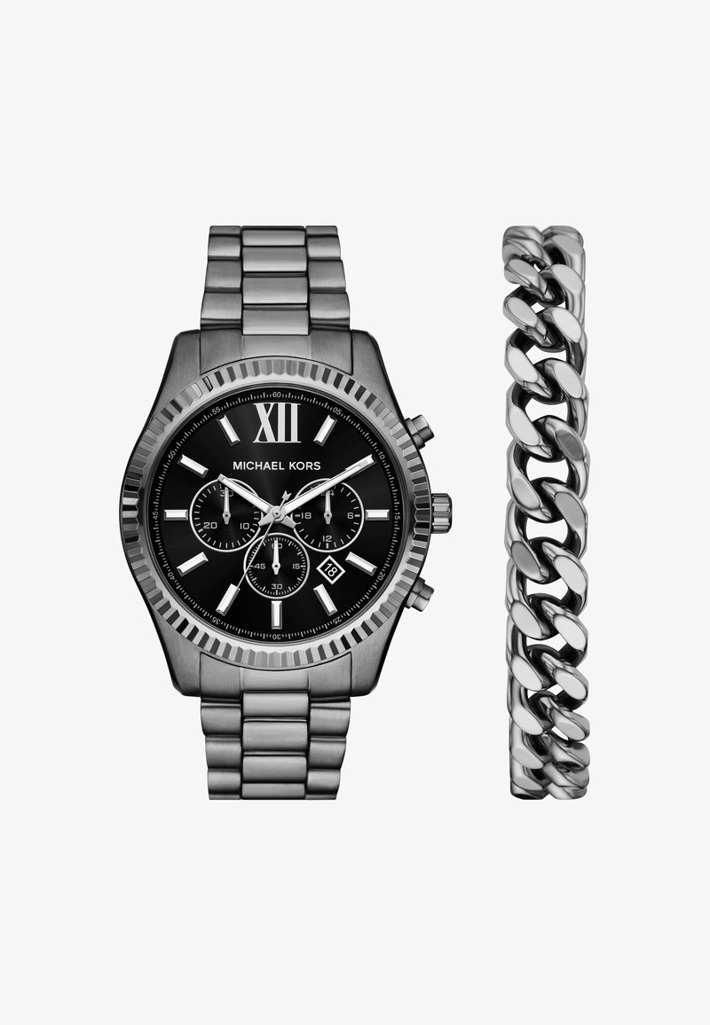 Orologio Michael Kors con quadrante nero, cinturino in metallo tono argento e numero romano XII; include un braccialetto a catena con anelli intrecciati.