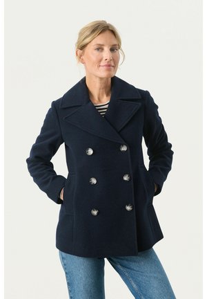 Cappotto doppiopetto blu navy con grandi bottoni, colletto a revers, tasche laterali e vestibilità strutturata, realizzato in tessuto morbido.