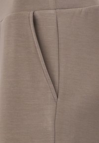 Beige fabric with a smooth texture featuring a side slit pocket. The design is minimalistic with clean, sharp lines.