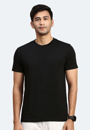 T-shirt nera in cotone con collo rotondo e maniche corte. Texture liscia e vestibilità regolare. Indossata da un modello su uno sfondo chiaro.