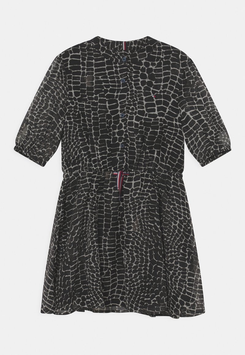 Robe noire avec motif quadrillé blanc irrégulier, devant boutonné, taille élastique, manches trois-quarts et lien coulissant à la taille.